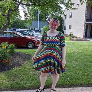 Sunny Funkhouser poses outside in a rainbow colored dress.