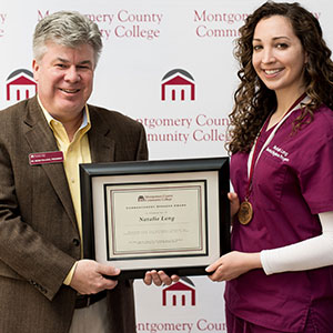 Dr. Pollock presenting plaque to Montco Student