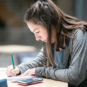 Girl at table, writing