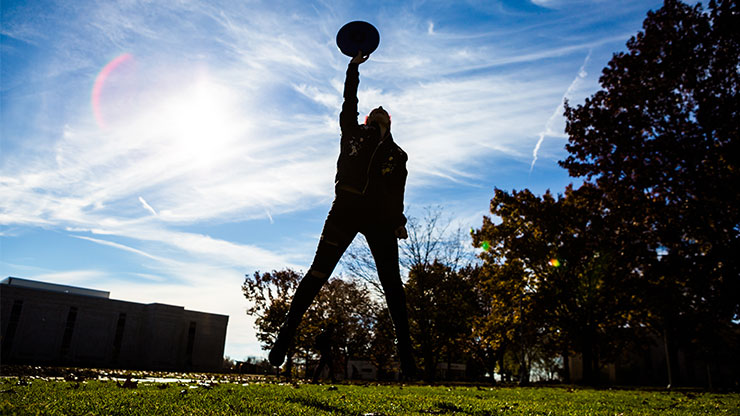 Person catching frisbee mid-air