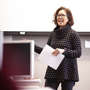 Female faculty memeber standing in front of class speaking