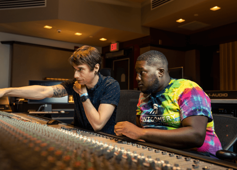 Two males sitting in a music studio