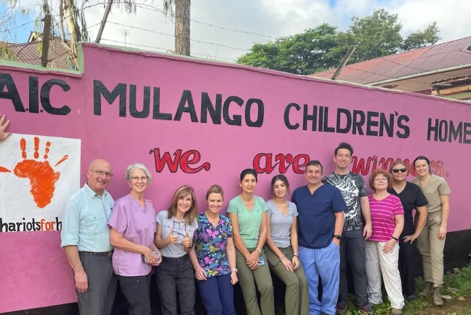 a group of people standing in front of a pink sign