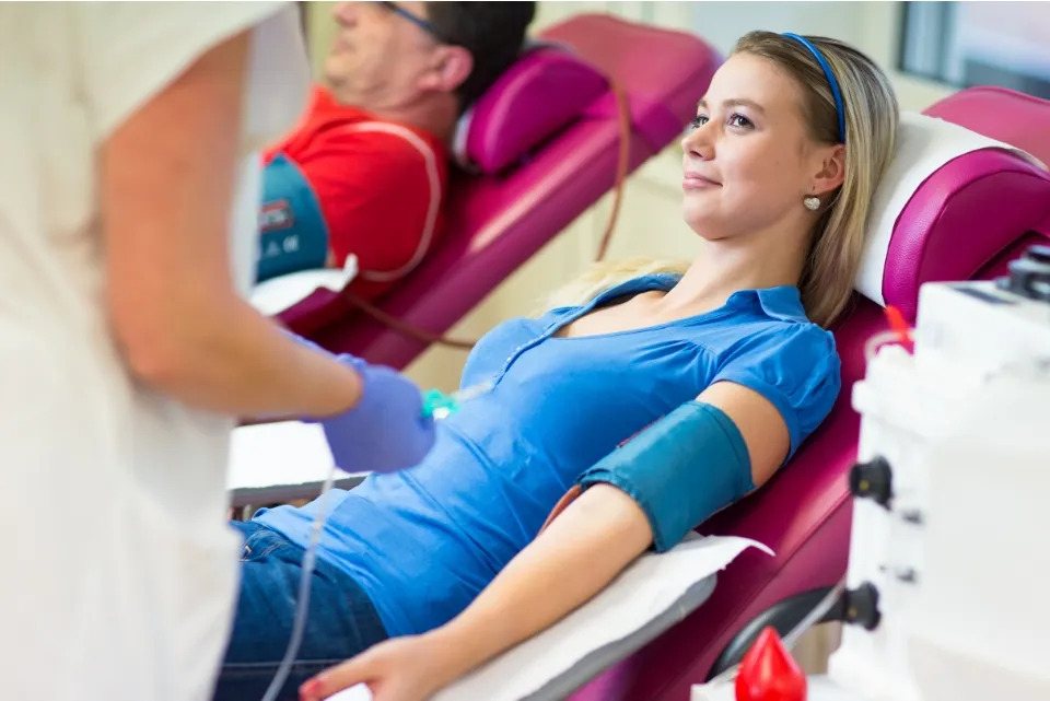 a woman in a blue shirt laying on a pink chair