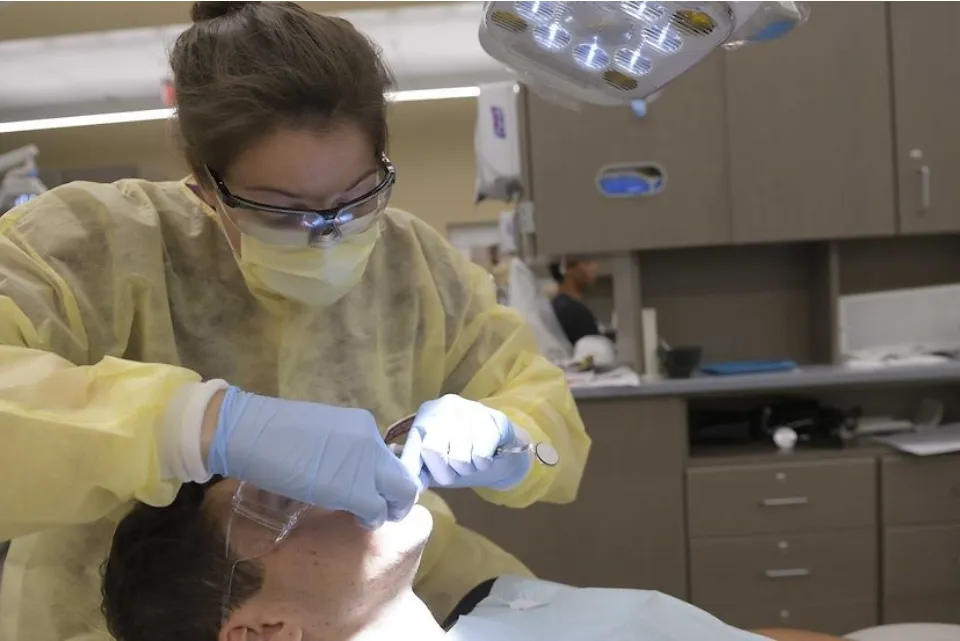 a man getting his teeth checked by a dentist