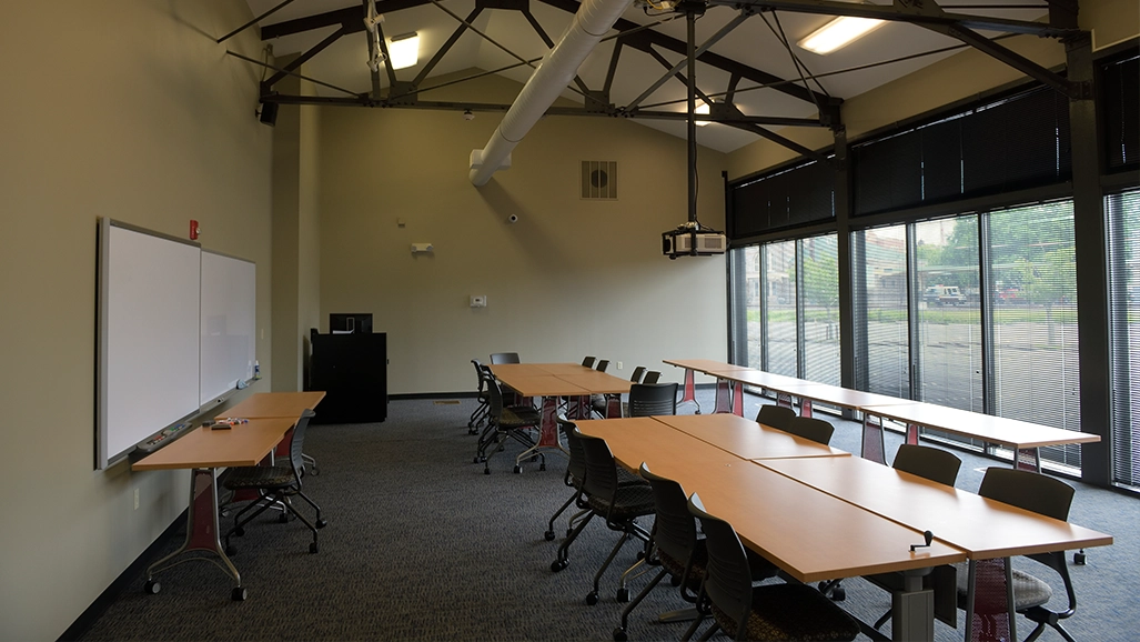 a classroom with a projector screen and desks