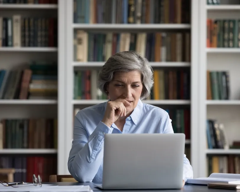 a woman sitting in front of a laptop computer