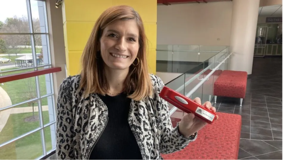 a woman holding a red stapler in her hand