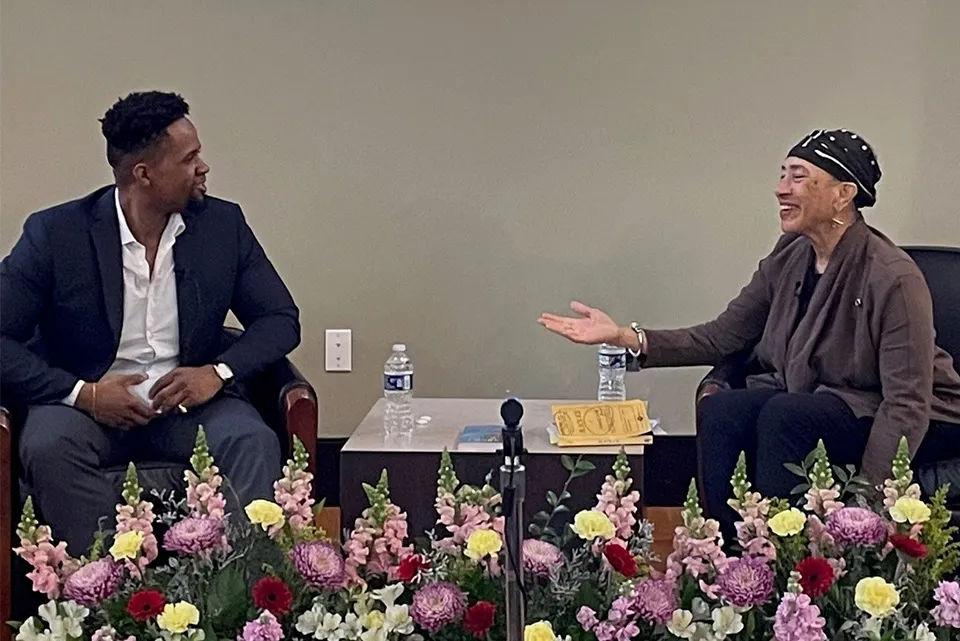 two people sitting in chairs talking to each other