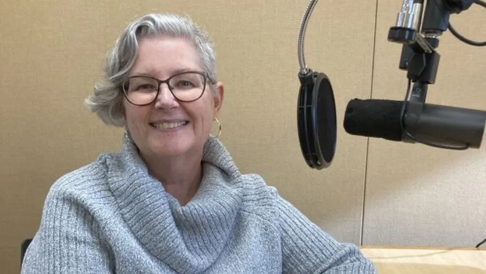 a woman sitting in a chair in front of a microphone