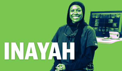 Image of Inayah smilling in front of a Dental X-Ray computer