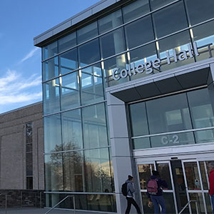 Front of College Hall with students walking into the building