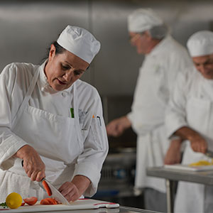 Female chef cutting vegetables
