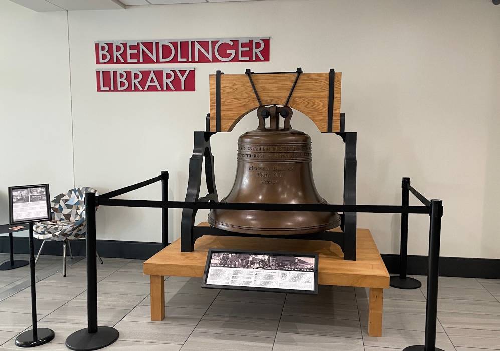 The Justice Bell out side the Brendlinger Library in College Hall