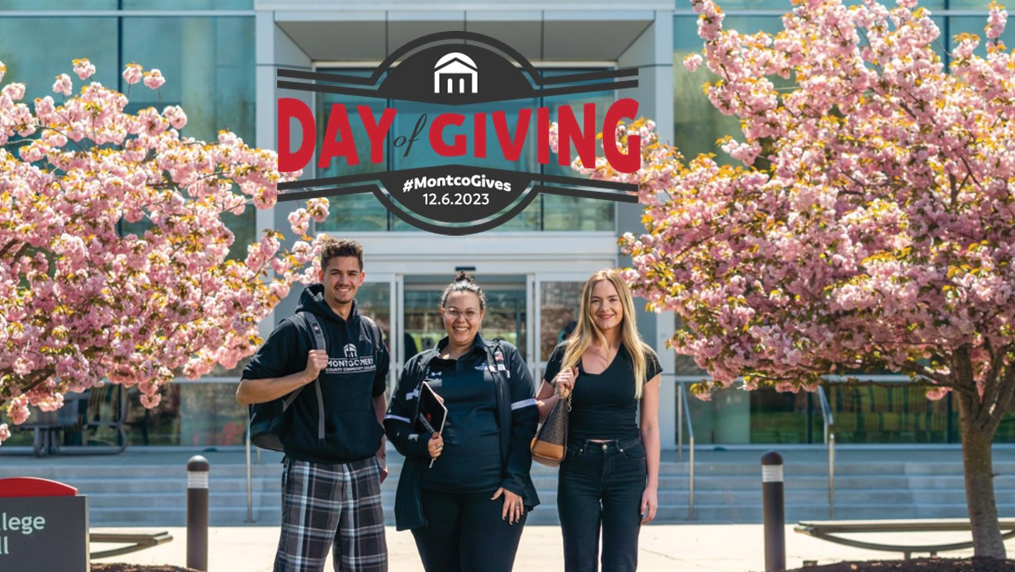 Three students in front of College Hall with Day of Giving logo