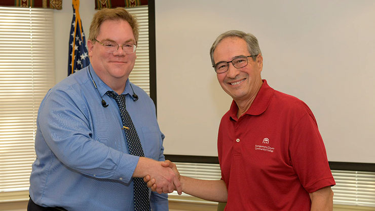 English Associate Professor and Montgomery County Community College Faculty Union President Harold Halbert (left) and Board of Trustees Chairman Richard Montalbano shake hands during the contract signing during Monday’s Board meeting.