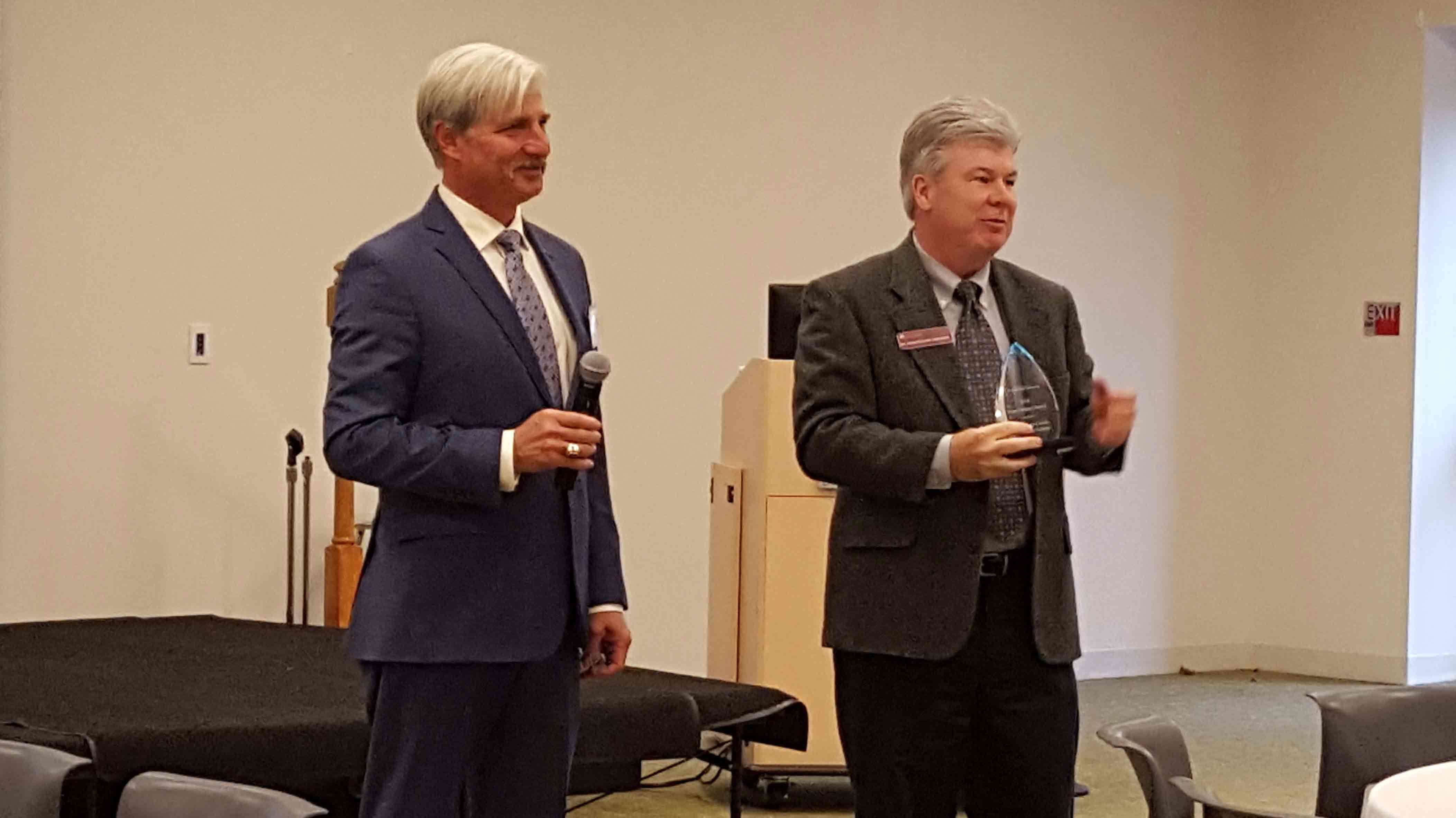 Montgomery County Development Corporation Chairperson Jerry Gorski (left) presents the 2018 Project Impact Award to Dr. Kevin Pollock, President of Montgomery County Community College.