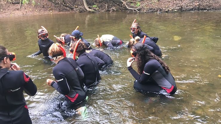 Campers put on wet suits to go creek snorkeling.