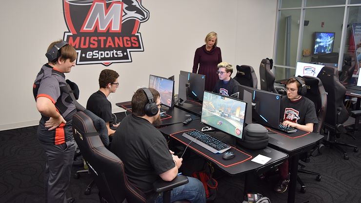 Montgomery County Community College's Mustangs eSports Coordinator Ryan Plummer (left) and Director of Athletics and Campus Recreation Kelly Dunbar (standing, right) coach student-athletes during a practice round of Rocket League. Photo by Diane VanDyke