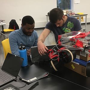 Noah Williams and Salvatore Sparacio work on a NASA Mars Curiosity Rover.