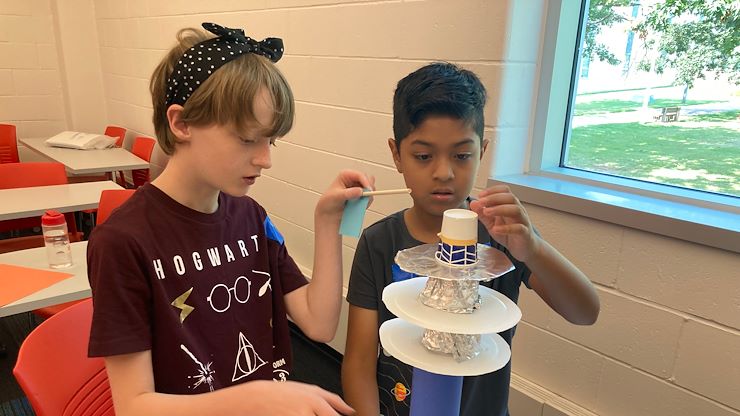 Campers in Janet's Planet Astronaut Academy work together on a model rocket project.