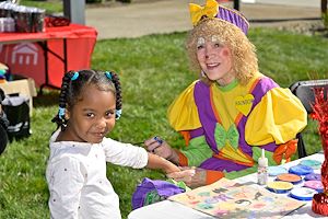 : Rainbow the Clown paints a little girl’s face during the Whitpain Community Festival. 