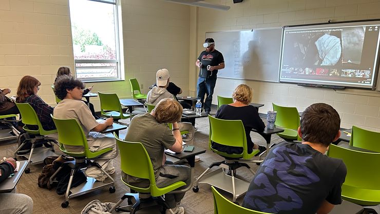 Communication Studies Assistant Professor Meredith Frank’s public speaking class watches a student give a speech while wearing a Virtual Reality headset. The technology is being implemented to alleviate speech anxiety. Photos by Eric Devlin.