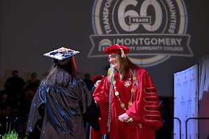 President Bastecki-Perez shaking graduate's hand