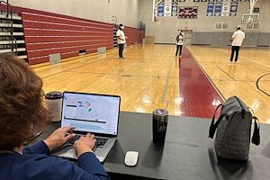 Nursing Associate Professor Dr. Christine Dunigan monitors her students on her laptop, as they practice treating a patient wearing virtual reality headsets.