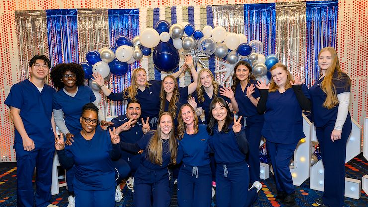 MCCC nurse graduates in front of balloon display