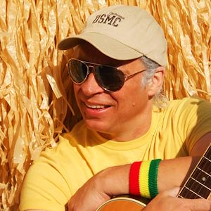 Larry Pearson the lead singer of Bluffett dressed in a yellow T-shirt, baseball cap and sunglasses.