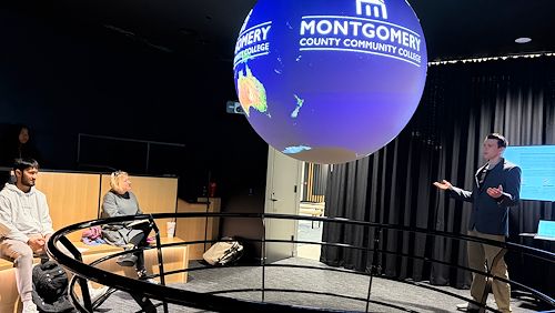 Montgomery County Community College Communications Studies 110 student Luke Wisniewski gives a speech on global weather patterns while incorporating the Science on a Sphere® in the lobby of South Hall on the Pottstown Campus
