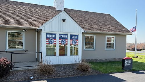 Exterior of the Veterans Resource Center on the Blue Bell Campus of Montgomery County Community College. There's an American flag on a flag pole in the background.