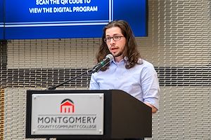 Kody Lewis, President of Student Government Association at Montgomery County Community College, speaks at a lectern.