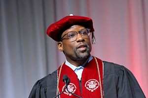 Donald Lyons, Chair of the MCCC Board of Trustees, dressed in red robes speaking at Commencement