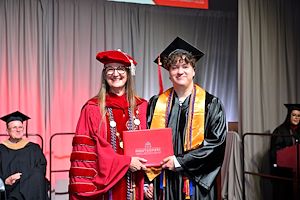 Dr. Vicki Bastecki-Perez with her graduating son, Zayne Perez, on stage together at Commencement.