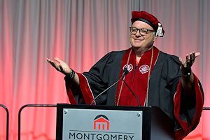 Montgomery County Commissioner Thomas DiBello dressed in red regalia gives a speech during Commencement