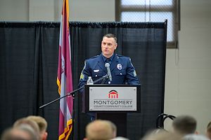 Sgt. Troy Senne speaks at a lectern during the Municipal Police Academy graduation ceremony