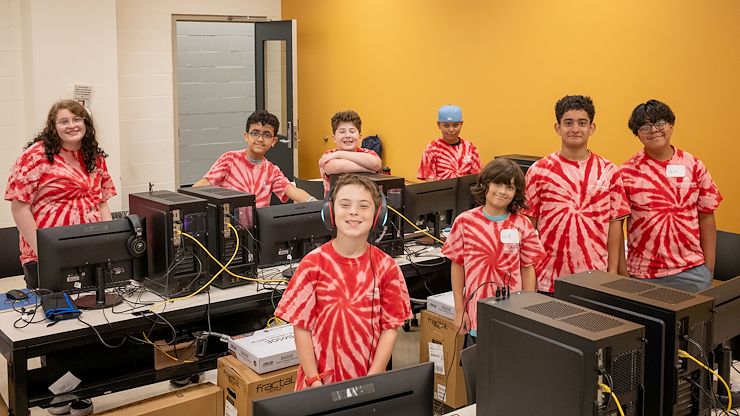 students stand next to the computers they built