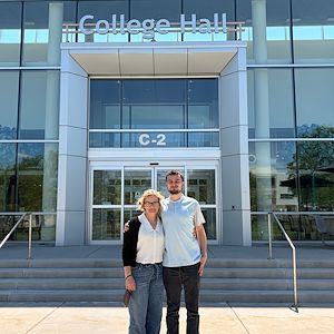 Aaron Laws and Courtney Morrow stand in front of College Hall on Blue Bell Campus