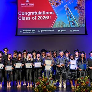 Group of Gateway to College graduate students are smiling on stage.