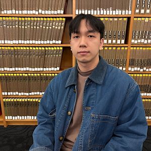 Gia Huy Nguyen in front of a book case in the library in College Hall